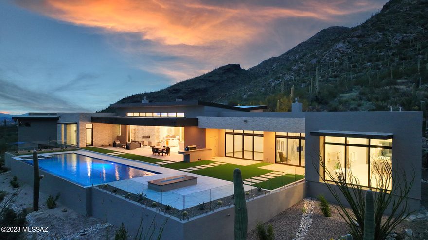 Immerse yourself in the pinnacle of luxury living with this expansive 5,661 sq. ft. residence, proudly nestled on a saguaro-studded 3.26-acre elevated lot within the coveted Pima Canyon Estates. This striking home, a testament to the architectural prowess of Marc Soloway of Soloway Designs, blends modern elegance and practical functionality, framed by awe-inspiring panoramic views of the city and the surrounding mountains.

This remarkable property features four generously-sized bedrooms and five bathrooms, each providing a tranquil sanctuary for rest and retreat. An accommodating office and exercise room add an extra layer of versatility to the home's sophisticated layout.