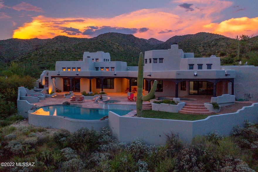 Discover a blend of soft contemporary and southwestern w/ SOARING 20'+ high, beamed ceilings in a dramatic, FLOWING great room of kitchen, family room, library and living room - all with walls of NEW, custom Jeld-Wen windows overlooking Tucson valley/lights/Catalina Mtns. EXTERIOR & INTERIOR NEWLY PAINTED. A soothing fountain takes center stage in entry experience. Owner's ensuite includes entry barn door,  double vanities, walk-in shower, jetted tub, large walk-in closet, bedroom w/fplace, LARGE WINDOW SLIDERS to flagstone decking leading to plunge/cocktail pool, hot tub and main swimming pool. S'mores can be the hit of outdoor f/place w/bancos. Kitchen chef's delight w/viking s/s appliances, island, breakfast bar. Circular drive leads to courtyard w/ stylish GRANITE, cascading waterfall