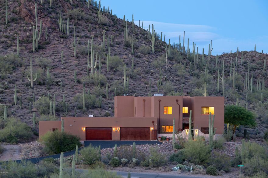 The only thing more stunning than the interior of this home are the incredible views from every window. Spacious, secure, and private, the Sonoran Desert tranquility optimizes the setting of this exquisite contractor's own custom-built home. ICF Construction for energy efficiency. Beautiful, natural luxury with imported hand-crafted Alamo cabinets and doors throughout, commercial stainless-steel Monogram appliances. Unique slate waterfall inside front entry, incredible formal dining room with wet bar, climate-controlled wine storage. Lower level stained concrete floors with slate baseboard throughout the house. Upper level carpeted 3 bedrooms with travertine stone baths and laundry room. Upstairs covered patio accessible from family room w/wet bar and Master Suite. Scenic patios overlook nearby Tucson Mountain Park and Sweetwater Preserve trails, all within walking distance. Four car garages with shop space and additional storage. Saguaro studded 3.3 acres hillside location offer maximum views.