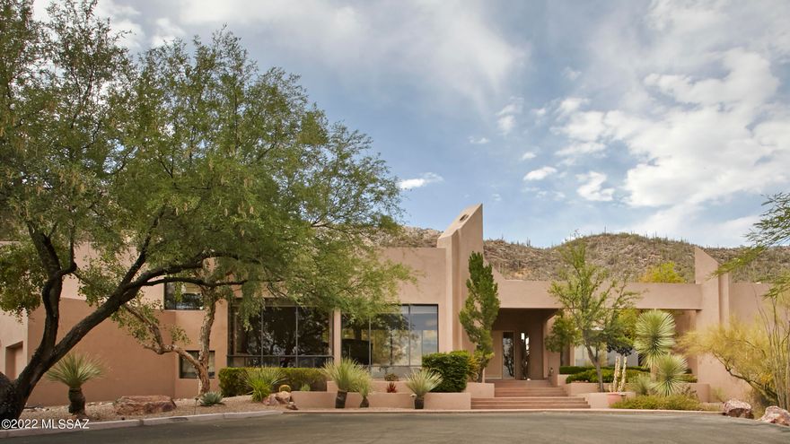 This exquisite architecturally unique contemporary home, on 1.6 acres, backs up to the Coronado National Forest in prestigious guard gated Finisterra Estates. An open concept design & floor to ceiling windows capture BREATHTAKING SWEEPING VIEWS OF THE SAGUARO STUDDED MOUNTAINS. The great room has 20' hi ceilings, walls of windows, a custom designed entertainment center, bar & fireplace. The dining room easily accommodates 12 guests. The kitchen is complete w/top of the line appliances, granite counters, a gourmet island, custom cabinetry, a walk-in pantry, a desk area & breakfast room. The master bedroom suite is on the main floor & features 2 lg walk-closets w/blt-in dressers. a luxurious bathroom w/a lg walk-in shower, a tub, dual vanities & exercise room or study. The additional bedrooms are very private.  Each has its own bathroom & walk-in closet. One of the bedrooms is currently being used as an office & has an off-the-wall bed.
Enjoy Tucson's outdoor lifestyle in the resort-like backyard featuring an inviting patio, a spa, professional landscaping, newly installed artificial turf, a blt-in BBQ & the unobstructed magnificent views. 
The 3 car garage has epoxy floors, lots of blt-in storage & a workroom. Community amenities include a clubhouse, heated pool, spa, tennis & pickle ball courts & security.  
Original owner. 
Very special property!