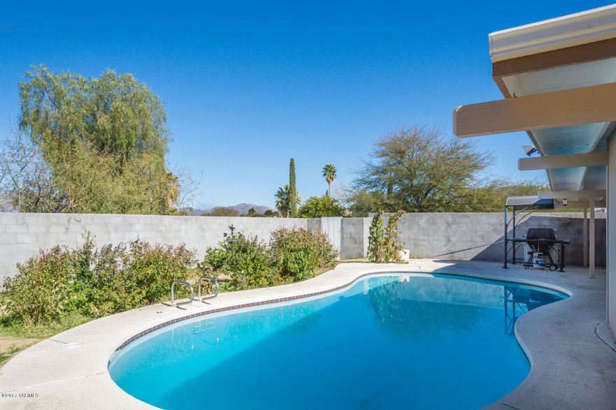 Beautifully remodeled home with tons of upgrades inside & out and a wonderful open concept floor plan!  Kitchen features knotty pine cabinets, granite counter tops with breakfast bar & fantastic tile backsplash. Private backyard offers a sparkling pool, large covered patios, mountain views & even a greenhouse!  Spacious master has ensuite bath with walk-in shower. Additional interior features include newer low-e dual pane windows, multiple skylights & ceiling fans, recessed lighting, newer gas pack heat & ac unit, water heater & lovely ceramic tile throughout. Located in the Lakeside neighborhood close to three nice parks, golf, schools, Davis-Monthan & Saguaro National Park, this is the one you have been waiting for!