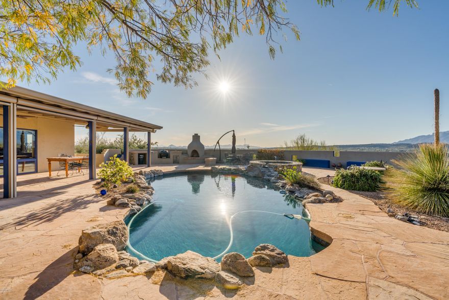 Two HOMES for the price of ONE in the Tanque Verde Valley with many uses...Multi-generational living, AirBnb, or Office/Studio. This 3.04 acre hillside property has panoramic views of the mountains and cityscape.  Enter the main home to view the artistic flare which makes it one of a kind. The kitchen boasts custom hickory counter tops, solid wood cabinetry with hand-forged hardware, instant hot water, custom island with pop-up electrical feature on wheels.  The living room & den feature double sided fireplace, custom built shelving and sliding doors to pool.  Large covered patio with automatic shades and sparkling pool, gas fireplace, horno, firepit, rain harvester and custom sundial.   Remodeled Guest House 1160 sf 2 BR 2 BA 2 Car Garage with views