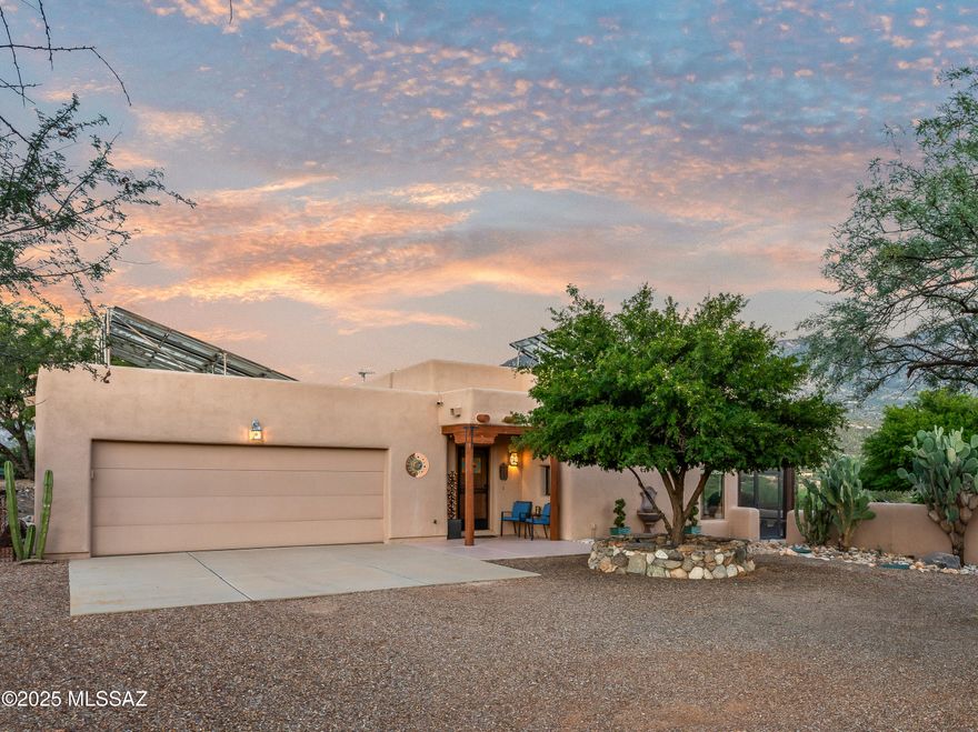 Discover authentic desert living on 4.2 private acres with sweeping Catalina Mountain views. This custom Santa Fe residence embodies warmth and craftsmanship—viga-beam ceilings, rounded arches, skylights, and beehive fireplaces inside and out create an effortless connection to the Sonoran landscape. The kitchen anchors daily life with chiseled-edge granite, an induction cooktop, pullout shelves, and abundant storage. The floor plan provides three bedrooms and two baths, plus a versatile flex room and a dedicated office with convenient garage entry. In the serene primary suite, heated bedroom floors offer year-round comfort, complemented by a walk-in shower and an in-bath washer/dryer. Outdoor living is where this home truly shines. The east-facing backyard invites cooler evenings on a screened patio with fans, a covered ramada for dining or lounging, and flagstone walkways. Practical upgrades includeleased solar, automated irrigation, and a Tuff Shed. The oversized, extra-wide and extra-deep two-car garage features a freshly coated floor, workshop space, and an EV charger. Set on a quiet road and zoned for horses, this property places you moments from Catalina State Park's trail network for hiking and mountain biking, with nearby shopping and dining for everyday convenience. An adjacent 1.5-acre lot is available exclusively to the buyer which isan opportunity to expand your footprint or secure added privacy. Owner/Agent.