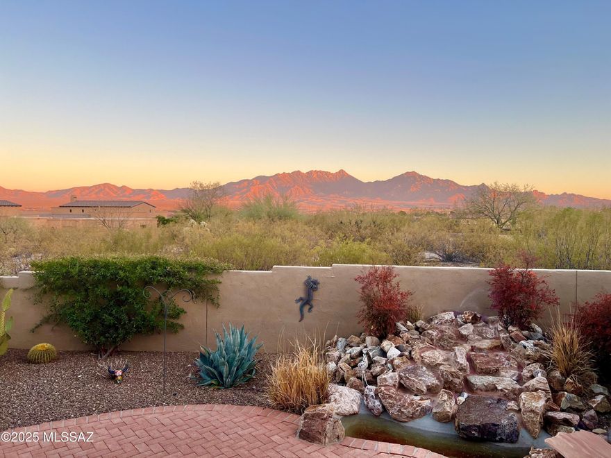 This exquisite home in a gated, non-age restricted community, offers panoramic mountain views and ultimate privacy on over an acre of natural desert landscape. A long brick paved driveway leads to a 3-car garage. Inside, enjoy tile floors throughout, with plush carpet in the bedrooms. The home features huge back windows, soaring ceilings, 8 ft solid wood doors, vigas and a striking beehive fireplace in the great room. Two primary suites each boast private baths. The kitchen showcases alder custom cabinetry, Santa Fe style ceiling beams, luxury granite and stainless steel appliances, including a wine fridge for entertaining. The formal dining room impresses with a coffered ceiling and tailored lighting. Privacy & luxury with stunning views combine in this must-see 
fully furnished retreat