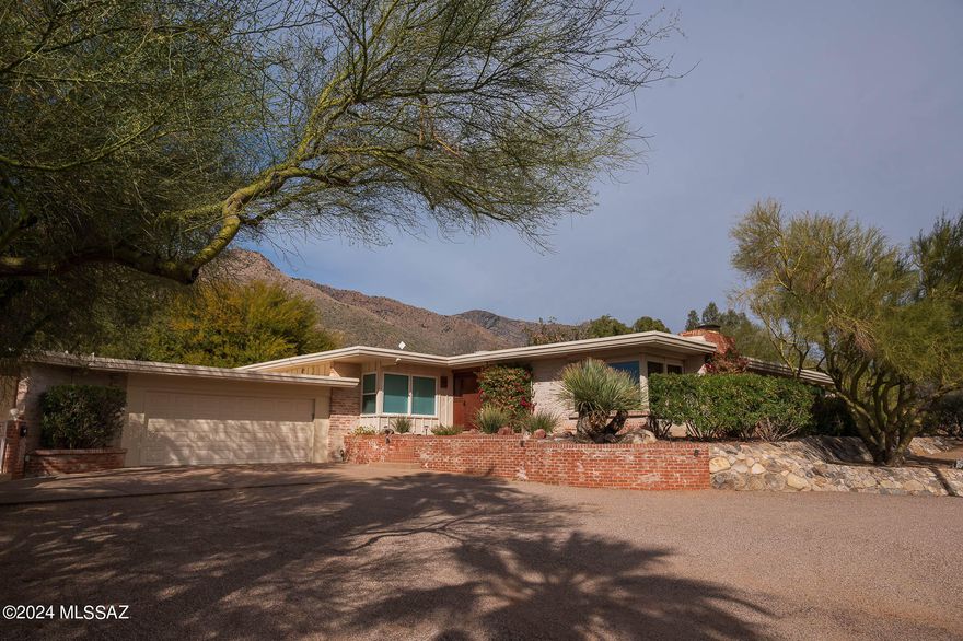 This beautifully remodeled home is a rare find in the established Skyline Country Club neighborhood. This larger home boasts 4 bd/4 ba in the main house plus sitting room/office in master,  and former 5th Bedroom is used as office/storage and has shelves but could easily be converted to a closet.  1bd/1 Guest House and a designated play set area and separated kid safe pool. The sport court will work for many options basketball, pickleball etc...
Enjoy stunning mountain sunsets and city lights from your large covered patio and pool. Full house & guest house remodeled in 2022. Modern kitchen with lots of light opens to large family room. Don't miss the amazing master retreat with a sitting room and newly remodeled bath.