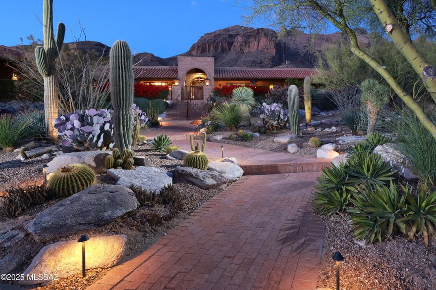 Nestled in the prestigious, gated Cobblestone community, this 4,339 sq. ft. custom territorial home offers an unparalleled blend of luxury, comfort, and breathtaking views. Impeccably sited to capture sweeping vistas of both the city skyline and rugged mountains, this single-level residence is a sanctuary of timeless elegance.

The expansive wrap-around veranda, complete with custom lighting, invites you to enjoy serene outdoor living and dining spaces framed by professionally designed landscaping, a tranquil courtyard fountain, and enhanced by new landscape lighting. Inside, the home boasts exquisite upgrades, including new stone flooring, refinished wood floors, and renovated bathrooms with premium finishes. The kitchen is a chef's dream, featuring an expanded island, granite countertops, a stone backsplash, and top-of-the-line appliances.

The thoughtfully designed layout includes a generous primary suite, an inviting den/library, and open living areas highlighted by large windows that perfectly frame the stunning views. An additional benefit is no interior steps throughout the home. Additional highlights include solid wood doors, custom cabinetry throughout, and charming stone fireplaces with custom mantles. The attached guest quarters with a kitchenette provide a private retreat for visitors.

With its oversized three-car garage and proximity to La Encantada's shopping and dining, this property offers both quiet seclusion and convenient access to the best of Tucson living. Experience the perfect balance of sophistication and comfort in this remarkable Cobblestone gem.
