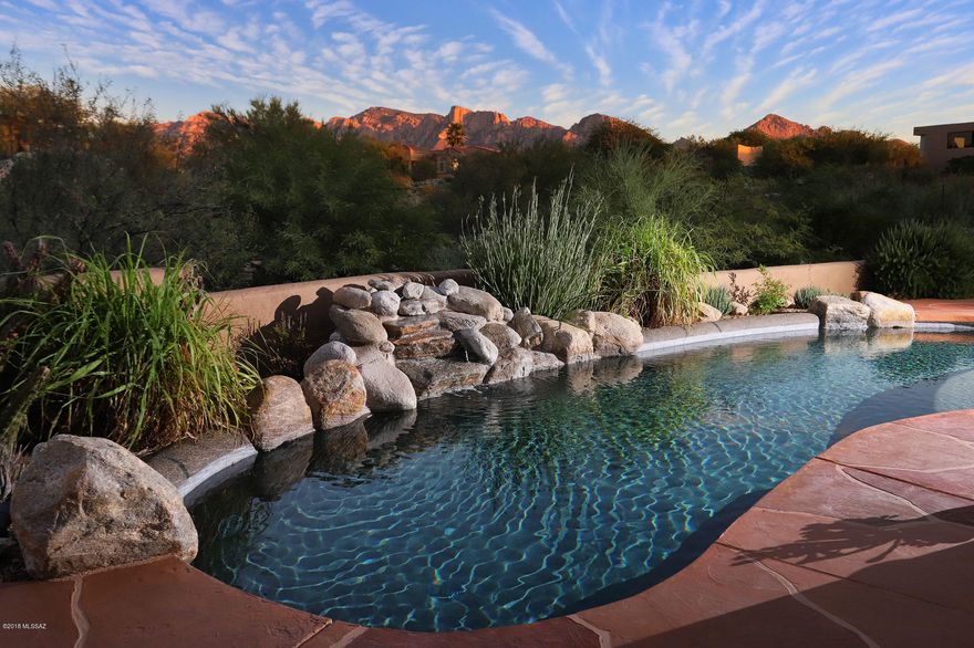 Seller shall entertain and/or counter offers between $795,000-$825,000. A living experience in the Oro Valley Area blending Indoor and Outdoor Living Spaces with a seamless design that let's the natural lure of Coyote Ridge embrace you as you enter this luxurious gated community, populated by custom homes with unsurpassed quality and design. This custom home reflects soft contemporary southwest architecture and is privately positioned on a 1-acre premier site  with amazing Pusch Ridge views. A private drive leads to a beautiful 3,859 Sq Ft custom home that features 3 bedrooms, 2.5 baths, access to the over-sized 3-car garage with skylights and epoxy flooring and secondary bedrooms that link to a Jack / Jill bathroom with travertine counter tops and Jacuzzi tub. Attention to detail embodies every space, nook and crevice. A culinary inspired  kitchen, equipped with stainless steel appliances, granite counter tops, knotty alder distressed cabinetry, walk-in pantry, 5-burner gas cook top, and a huge prep island with breakfast bar and built-in vegetable sink. A perfect set up to prepare family meals or for entertaining on a larger scale. The kitchen flows perfectly into the formal dining room where you have unobstructed views of the Catalina mountains and circulates to the expansive great room that features 14' ceilings, 8' knotty alder doors, a floor-to-ceiling gas log fireplace accented with flagstone, lighted display shelving, and sealed travertine tile throughout. Just off the great room is an entertainment media/theater room with surround sound where you can relax and enjoy a theater-like experience right in the comfort of your own home. Grand double entry doors lead you to the superb master suite that includes a full-scale walk-in closet, soaring ceilings, a spa-like master bath with executive height vanity with 2 custom sinks set in travertine, an oversized jetted tub, large walk-in shower with multiple shower heads, and French glass double doors that lead to the covered veranda + pebble tech pool.  The Tucson lifestyle shines in outdoor living, bringing paradise to the external areas of your home, as well. An ideal east facing backyard oasis with the most spectacular mountain views in the area, letting you witness the reflection of the colors of ancient sunsets, right before your eyes. From the fine quality of construction and well thought out floor plan, your expectations can be easily met!