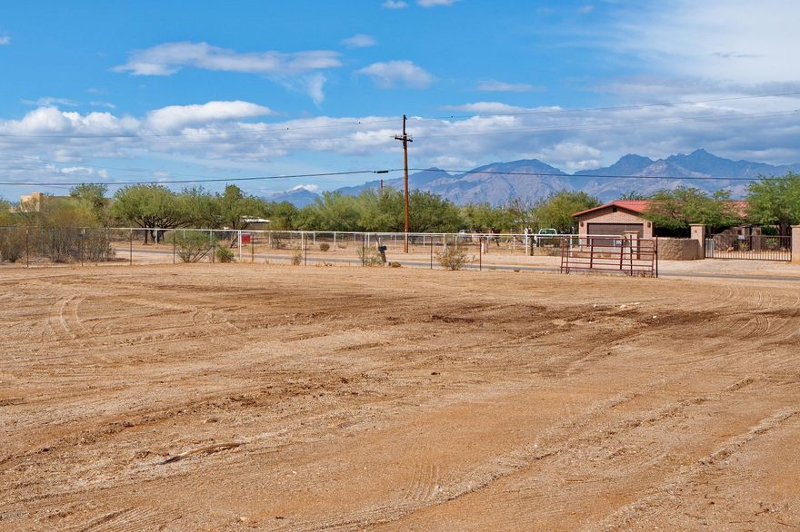 Large fenced and gated area for horses or hobbies with water and shade structure. Wrap around 360 degrees covered patios with metal roof and 4 vehicle truck port. No flood zone, no washes on property! 2002 built home has 3 bedrooms and 2 bathrooms. City water and sewer. Cleared flat lot, no HOA. Contemporary interior with 2019 AC, high ceilings, ceramic tile floors, ceiling fans, walk in closets and open living area. No Carpet! Plenty of excess land for pool, ramadas and entertaining space. Nearby wash for riding.