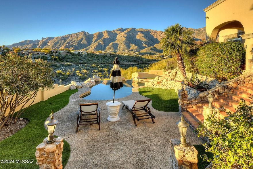 Nestled against the backdrop of the Catalinas and brimming with character & charm, this single story home sitting on nearly 2 acres is a testament to refined luxury. The gated courtyard welcomes with tranquil fountain & kumquat trees. Mesquite front doors lead into the living/dining rooms with unobstructed mountain, & city views. Primary has a sitting room, fireplace & beautifully renovated bath with double marble vanity, soaking tub & 2 walk-in closets. 2 add'l bedrooms share a renovated Jack & Jill bath with double vanity, walk-in shower & fully tiled walls; there is also a large den with fireplace & office with its own patio & city views that easily converts into a 2nd primary (4th bedroom). High, beamed, wood plank ceilings offer a touch of rustic elegance. The gourmet kitchen is equipped with high-end appliances, large island & raw-edged granite countertops.

6 sets of screened Andersen French doors lead from the house to the inviting patio & backyard with infinity pool & waterfall overlooking panoramic views. A built-in BBQ, gas fireplace, & ample covered seating areas invite al fresco dining and lounging, creating an outdoor entertainment oasis. Low HOA dues, upgraded HVACs, and air quality & water softening systems add to its appeal. This home seamlessly blends sophistication w/comfort. Come experience gracious, relaxed, Tucson living at its best!