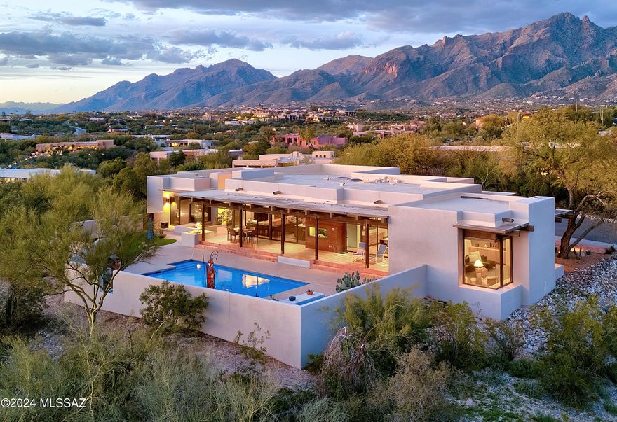 Stunning architect designed soft  contemporary,1.3 ac. ridgetop homesite w/majestic city & mt. views in prestigious gated Catalina Foothills Est.#10. Exceptional home w/ long private driveway & sparkling entry fountain.  exquisite living rm w/ dramatic floor to ceiling windows, 11ft. Douglas fir beam ceilings, fireplace, formal dining rm w/built-ins, wet bar, gourmet island kitchen w/quartz countertops, Miele SS appliances, dbl ovens, pantry, breakfast area, family rm w/fireplace, tile floors, 3 bedrooms + study/exercise rm, 3 baths, primary bedroom w/sitting area, fireplace, lux. bath, large walk in closet, laundry rm & oversized 2 car garage w/storage rm. Enjoy gracious outdoor living w/ covered patio, gas heated 30'x14' lap pool, turf, lush landscaping, fab views & Dist. 16 schools.