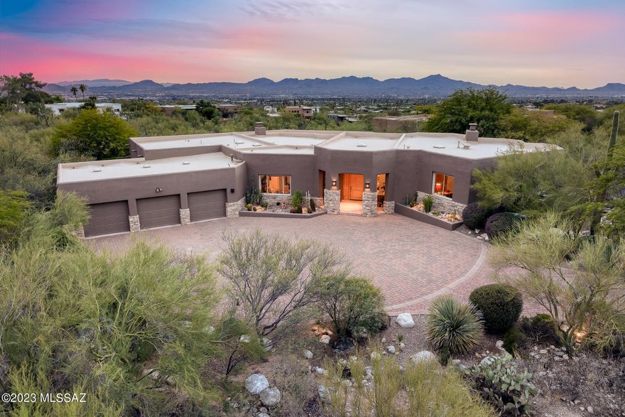 Welcome to your serene desert oasis nestled in the prestigious gated community of Pima Canyon. This luxurious 3713 sq ft, 5-bedroom, 4-bathroom residence sits on nearly 1.5 acres of meticulously landscaped desert terrain. Greeted by breathtaking vistas of the Catalina and Tucson Mountains, as well as captivating city lights, this property boasts panoramic views in this elegant setting. Designed for both privacy and functionality, the split-bedroom plan offers tranquility and space for all. The heart of the home, a spacious chef's kitchen, features top-of-the-line Viking stainless steel appliances, perfect for culinary enthusiasts and entertaining alike. Step outside to an entertainer's paradise - a negative edge pool and spa invite you to relax while soaking in the stunning surroundings.