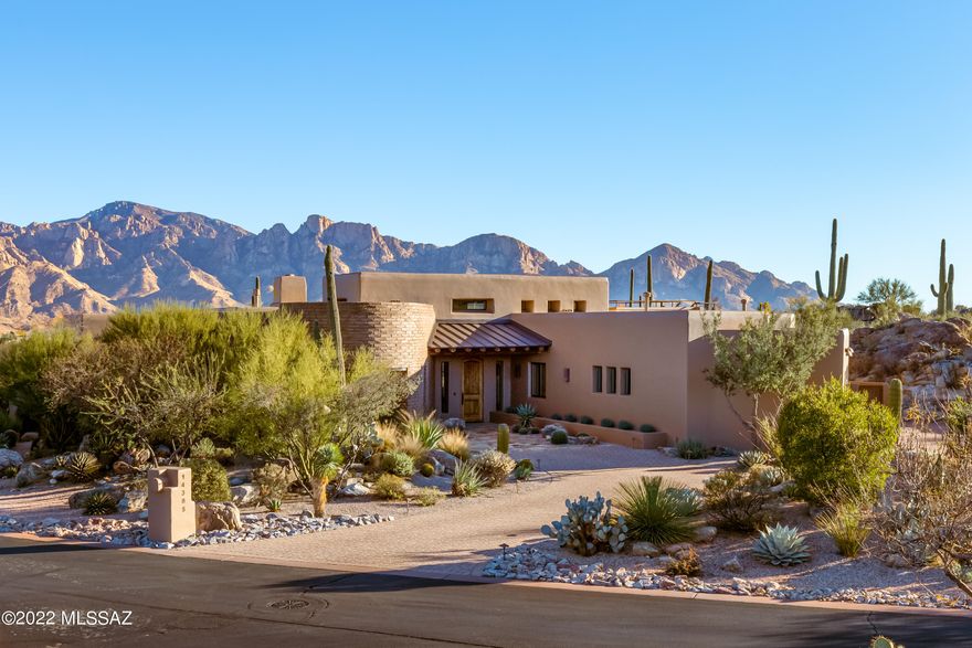 Ron Robinette designed custom Masonry constructed 3,775sf, 4BR/3½BA in gated Honey Bee Ridge Estates in Oro Valley w/Catalina Mountain Views. Great room has curved adobe accent wall, custom lighting, 9' folding door window wall to patio where mountain views pour in, Gas Kiva fireplace w/banco. Kitchen has granite counters, Dacor, Sub Zero stainless appliances, casual dining area w/Kiva w/granite slab raised hearth. Master suite has vigas within raised ceiling, sitting area, private access to patio & designed walk-in closet. Luxurious bath has Kohler air jet tub, Jura beige limestone vanity & spa deck, freestanding doorless shower w/dual shower heads & bench & heated floor. 4th BR used as office w/Mesquite hardwood flooring, built-in credenza w/computer workspace. Guest suite has Gascogne Blue limestone counter w/dual sinks & walk-in shower w/bench. Floors are Rogo finished scored concrete, flagstone or hardwood throughout. Wrap around flagstone patio w/mountain view & lush natural desert landscape & rock outcroppings; eastern portion is fully covered; southern portion has rusted steel ramada for winter sun, built-in BBQ w/sink, stairway to amazing viewing deck. 3-car garage has epoxy coated floor, storage closets & work bench. Additional features list under the documents tab.
