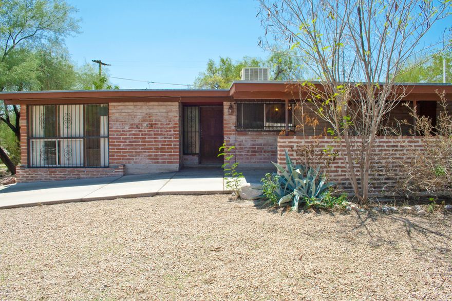 This light, bright centrally located brick charmer has a new roof from 2016 & upgraded electrical 2014. Enjoy the private south-facing backyard on your large corner lot with mature shade & citrus trees and a vegetable garden. The attached carport includes a huge storage room with windows & electric which could double as a workshop. Set back from Grant Road, a large block wall was added to the front yard for additional privacy while still providing great Catalina views from the sunken living room & third bedroom. Located just minutes from Udall Park, Tucson Medical Center, Tanque Verde's ''Restaurant Row,'' and access to The Loop's 120 miles of shared-use paths, this home is also convenient to BASIS Tucson North & the Catalina Foothills School District with its open enrollment policy.