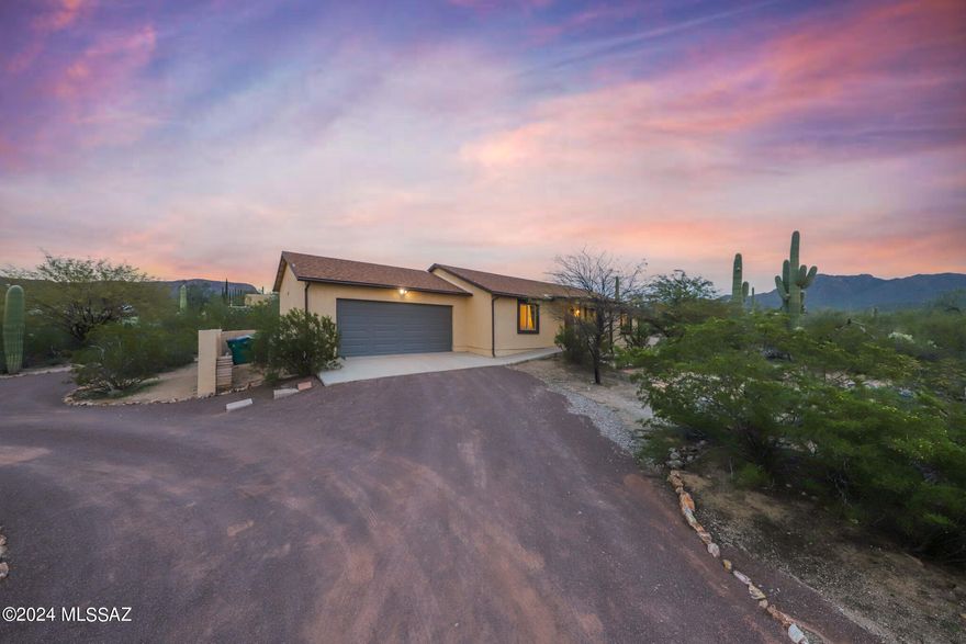 Welcome home! This lovely 3 br/2ba custom built home is on a saguaro studded 1.3 acre lot. Located only a mile from Saguaro National Park West, the beauty of the desert and mountains surround you with incredible views! You'll be greeted by an impeccably landscaped driveway that integrates the natural vegetation and leads to your two car garage. Feel right at home upon entering with the open living area, high ceilings, split bedroom floorplan, and contemporary touches! Features updated gray wood-look tile throughout and carpet in the guest bedrooms. The spacious kitchen has plenty of cabinet space, a pantry, and stainless steel appliances. Refrigerator, washer, and dryer convey! The fenced in backyard is great for pets and children alike. All of this and only 15 min to I-10!