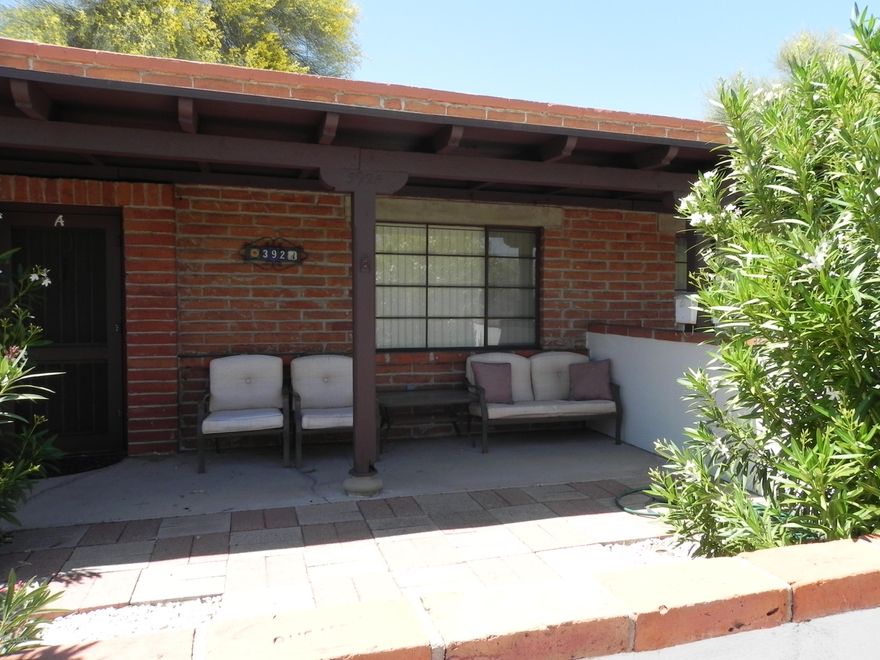 Charming and bright, move in ready condo with large east facing paved patio.  This home has a kitchen nook addition with indoor laundry room.  Close to shopping and I-19 with assigned and guest parking in front for extra convenience.  Fully furnished unit, excluding brown recliner, includes housewares and small appliances. This home is perfect for escaping cold winters, scaled down living or rental opportunity.