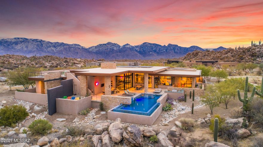 Striking desert contemporary by top local architect Kevin Howard enjoys serene and private vistas of the rugged, saguaro-studded Tortolita Mtns. Located high in Stone Canyon, Phil Mickelson's exclusive guard-gated golf community, this stunning design uses superior natural materials throughout offering every amenity for gracious living:  great room with disappearing window wall & awesome kitchen, 700-bottle wine cellar, large dual office, 2-level theater, 3 guest suites, fabulous master with spa-like bath, separate commodes, snail shwr plus massage/exercise rm. Outdoor amenities offer true AZ style relaxation: neg edge saltwater pool & spa, linear gas firepit & TV sitting areas, BBQ, rooftop deck w/360° views of rugged Tortolita & majestic Catalina Mtns. Furnishings avail. Membership req'd