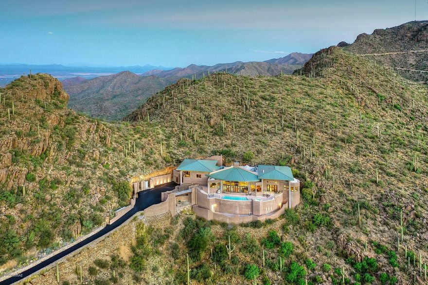 Seller will consider offers between $1,950,000 and $2,250,000.''The highest home in Tucson'', with world-class views from this spectacular contemporary perched high atop the Tucson Mountains — 1,500 feet above the city floor.  The home offers a total of 9,284 sq. ft. including the 5,625 finished main level and 3,659 partially finished lower level (rooms could be used for  wine cellar, workshop, game room, theater, gym/exercise room, shooting range). This remarkable property is situated within two gated communities on 7.72 acres including tax parcels 212-06-075A and 212-06-079B.  From mountain range to mountain range, walls of windows capture the entirety of the Tucson valley, sunrises, sunsets, city lights and yet close to downtown and the University of Arizona. Carved out of the mountain, featured are 25' ceilings, 40' columns, four roof structures,glorious great room opening to the chef's kitchen, gracious master suite with sitting room, soaring domed master bath ceiling and loft/library.  Built in 2009, with remodeling completed over the past four years, this showplace with pool and spa is surrounded by Tucson Mountain Park and Saguaro National Park.  Sit back in a sanctuary of silence and creation