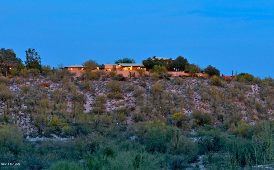 This is a classic “Old Foothills” home situated on a high hill top with 360 views.  A sense of privacy and seclusion is felt as you enter along the paved .25 mile private drive.  Charm and character surround from the moment you enter the front courtyard with custom gates, brick pavers and canopy of mesquite.  Massive wood beams, brick floors, soaring ceilings, expansive covered patios, built-ins, and walls of windows provide a great sense of ambiance.  The Master suite is a private retreat with sitting area, huge walk-in closet, and completely remodeled luxury bath.  The huge eat-in kitchen features a large granite island and ample cabinets.  Multiple exterior spaces include the pool/spa area with water feature; olive grove area; bocce ball court; and walled ''kids'' area.