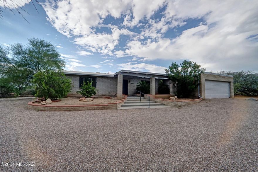 Oh, the convenience this location has!  Close commute to U of A, downtown, bus lines, shopping, excellent schools, & fine dining!  This lot offers fantastic mountain and sunset views from your backyard pool area.  Lots of hardscape for entertaining & room  for an outdoor kitchen, etc.  The lot is almost a full acre bordered by a wash behind for lots of privacy. The inside offers an updated kitchen with lots of storage and cabinetry. A separate family room provides a large wood-burning fireplace with a nice hearth for the holiday gatherings.  No popcorn in this home, newer tile in most areas. This home will offer comfort & convenience  for anyone seeking the Foothills for their new neighborhood.