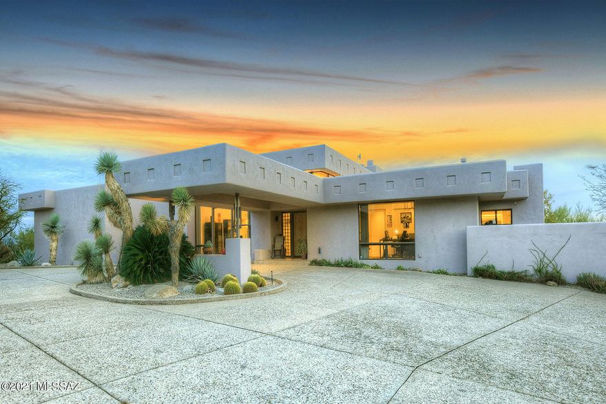 High on a hill in prestigious, guard-gated La Paloma Estates, this remarkable 4,737 sq. ft. Tyson-Murphy contemporary offers top-of-a-cul-de-sac location with sweeping Catalina Mountain & city views! Highlights include a long & winding driveway, a dramatic porte-cochère entry, a grand foyer, soaring wood-planked ceilings in the main living areas, three fireplaces, neutral ceramic tile flooring, and walls of windows framing scenic views. The fabulous gourmet island kitchen, open to the family room, provides granite countertops, stainless steel appliances, and an oversized walk-in pantry. The gracious master suite features a wall of glass, a cozy fireplace, a walk-in closet, dual vanities, a spa tub and a steam shower. The attached guest quarters offer a living room with a kitchenette & breakfast bar, a bedroom with walk-in closet and a bathroom. The generous 3-car garage includes a storage room. Enjoy the beautiful back patio featuring an expansive covered porch, a built-in bbq, a spacious walled-in yard with play areas, a sparkling pool/spa, and sweeping vistas. District 16 Schools.