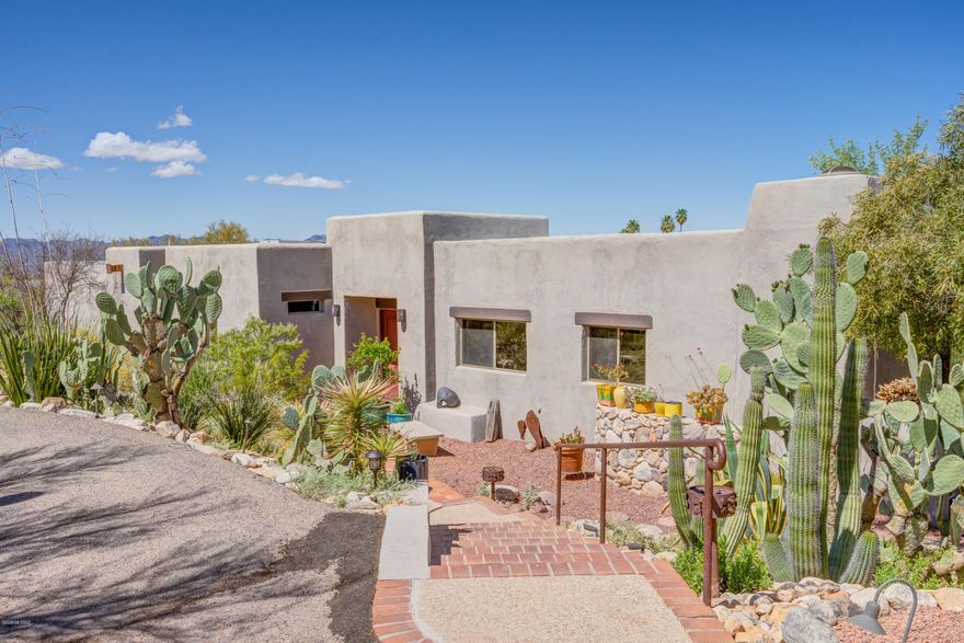 Feel drawn into nature in this tranquil and very private 1.3 acre natural desert setting in central foothills. Enjoy unobstructed Catalina mountain views, gorgeous sunsets, and numerous saguaros! This well-maintained home has durable brick floors in living areas and beamed ceilings originating from Mt. Lemmon. Kitchen has solid cherry cabinets and expansive granite countertops. Hearth room off kitchen features a unique fireplace. Large bedrooms have concrete floors and lots of storage—4th bedroom has 2 private entrances. Master bedroom features a fireplace, slate floors and patio entrance. Multiple outdoor spaces for entertaining and relaxing. Recent improvements: garage floor re-coating, roof re-coating (with warranty) and pool deck resurfacing. Two quality rainwater harvesting tanks. (tank capacity of 1000 gal. and a 500 gal.) This "old foothills" neighborhood offers great walking areas and access to shopping and schools. Don't miss this opportunity to live in what many have said is the "best neighborhood in the foothills"!