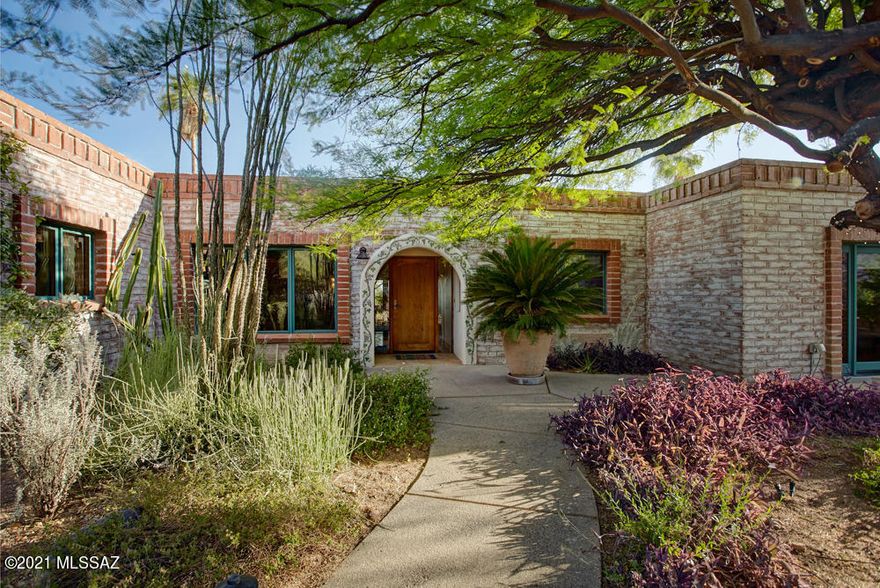 Classic foothills burnt adobe with a unique contemporary flavor.  Sited to capture city and mountain views, the property has a lushly landscaped front courtyard and is surrounded by lovely gardens.  The beautifully remodeled open concept kitchen w/custom cabinets, spacious center island, Thermador range, built in refrigerator and wine cooler is a chef's delight.  Two  master bedrooms with ensuite baths, walk-in closets are perfect for families or guests.  Enjoy Tucson's lifestyle at it's best in the backyard space featuring a  Pebble Tec pool, built-in BBQ, Ocotillo-ribbed covered patio, outdoor shower, and an cactus garden.    Brazilian rosewood floors and solid alder doors enhance the charm and warmth of this home.  Don't miss this great property!