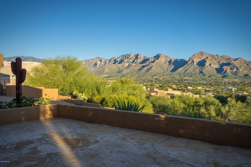 360 view stunner! Sweeping views from virtually every room in this beautifully finished 4 bed split + den. Open concept living space features coffered ceilings, expansive windows with jaw dropping views & gas fireplace. Gourmet kitchen with granite topped counters, stainless appliances including 5 burner gas range with pot filler, large walk-in pantry & oversized island/breakfast bar. Master suite offers views, huge walk-in closet and spa-like bath with walk in shower, jetted tub, dual sinks, private lav with separate bidet. Convenient den and half bath off living space. Captivating vistas from all three guest bedrooms & both full guest baths. Resort style backyard space overlooking the Tortolitas and golf course, complete with pool, putting green & built-in BBQ. 4 car garage with ½ bath.