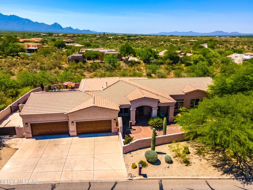 This spacious home is nestled in the sought-after Madera Reserve Community. This premium plus half-acre lot boasts mountain views with a wooded arroyo affording spaciousness and privacy. This classic ranch offers three bedrooms each with its own full stunning bathroom. The huge master suite possesses a sitting area, in addition to a walk-in shower and whirlpool soaking tub.  The gourmet kitchen provides an abundance of hickory cabinetry, granite countertops, and a pantry. All appliances are new, including a Bosch drawer microwave, dishwasher, and cooktop. The enormous kitchen offers eat-in space, as well as a sitting area. The laundry, unique powder room, and utility room are adjacent to the kitchen. The separate dining room, living room, and office/den complete this expansive interior. There is ceramic tile throughout the home with an abundance of closet and linen closet space. In addition, the garage houses four cars with a large 17' X 22' storage area, as well as an outdoor parking area adjacent to the garage.  Relax in the solar-heated in-ground pool perfect for Arizona weather.  The north/south home exposure offers covered patios each with its own courtyard.  Surround-sound music will enhance your indoor and outdoor experience. Whole house H2O water filtration system included