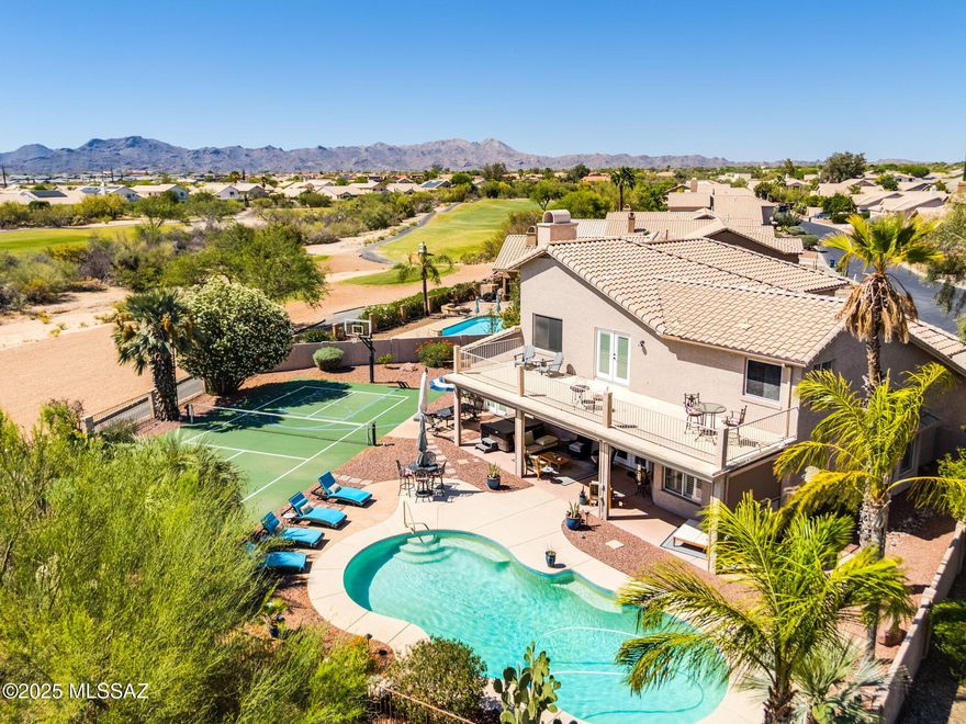 Luxurious 4BR/3BA+Den (3,811 sq ft) two-story home on golf course offers a new roof, no poly, resort-style yard with sparkling heated pool, hot tub & pickleball/basketball court plus panoramic mountain views! Soaring vaulted ceilings and spiral wood banister staircase greet you. Formal living & dining areas flow to an informal gathering room with media wall & wet bar plus gourmet kitchen hosting Breakfast Bar-Nook-Island, custom cabinetry and granite/stainless amenities. Upper level hosts private Owner's Suite with spa-like bath, fireplace & balcony with views plus 2 bedrooms, hall bath and Den. Large guest room on main level lies off a hall bath. Additional amenities include plantation shutters, bay windows, newer French doors, security features and 3-car garage with keyless entry. Relax on the covered rear patio with rolling sunshades overlooking lush landscaping plus golf course and mountain views. Close to Oro Valley Community Center, schools, dining & entertainment. A true desert retreat!