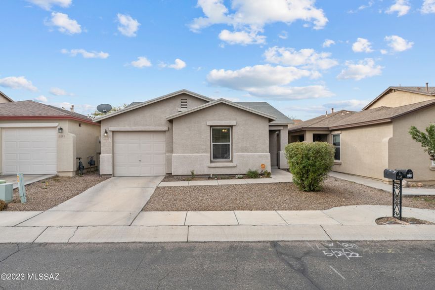 Cute as a button, move in ready home in the Northwest Tierra Del Paraiso neighborhood. The adorable two-bedroom home boasts numerous updates since 2020 including wood look laminate floors throughout, new baseboards, lighting & plumbing fixtures. White kitchen with breakfast bar, newer stainless appliances including a gas range & side by side refrigerator. Bath with free-standing vanity with raised bowl sink. Round decorative mirror & floating shelf convey. Laundry closet with 2020 Samsung washer & dryer. Relax on the covered patio with ceiling fan &  enjoy the cute backyard with raised beds perfect for planting herbs & flowers. Fenced yard for pets. Security system. 2020 HVAC. Roof replaced 2023. One-year home warranty included. Why rent? Make this your home sweet home today!
