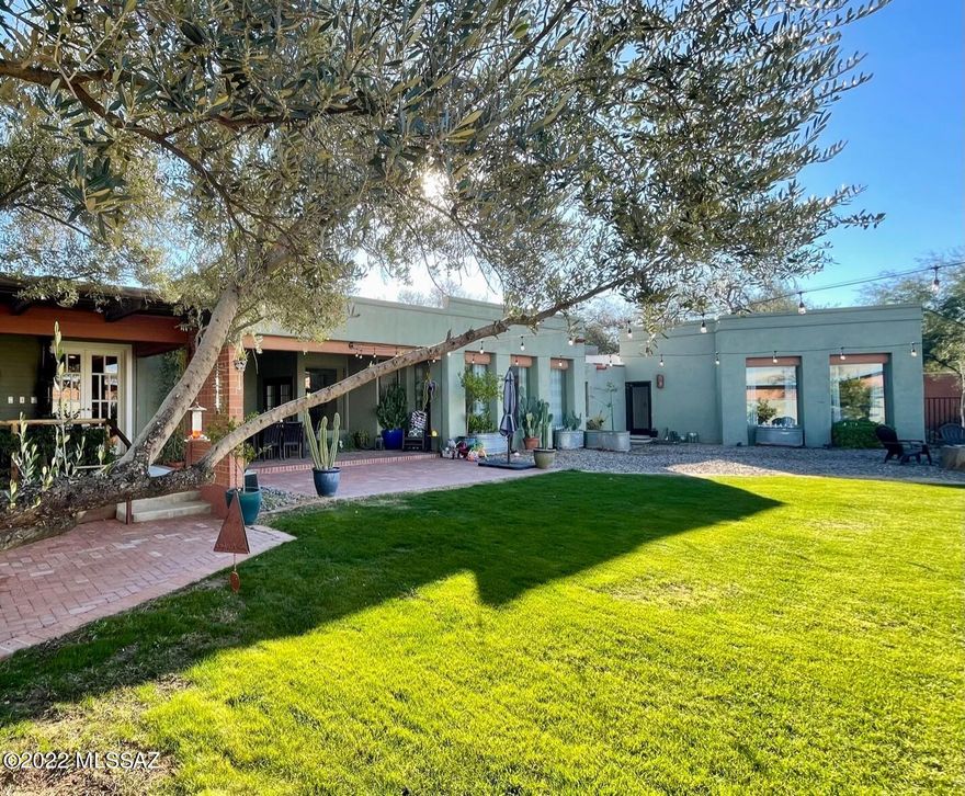 This sprawling home in Historic Catalina Vista strikes a lovely balance between vintage details and modern amenities. Enter through the living room and dining room to a wall of windows in the large media/family room which opens to the outstanding back yard. Custom metalwork, citrus trees, and two porches make this a true oasis. Inside a split plan offers 3 bedrooms and two bathrooms plus a primary suite with walk in closet, stunning en suite bathroom, and adjacent den/office with beamed ceilings. Minutes to the Arizona Inn, Banner Hospital, and the University of Arizona.
