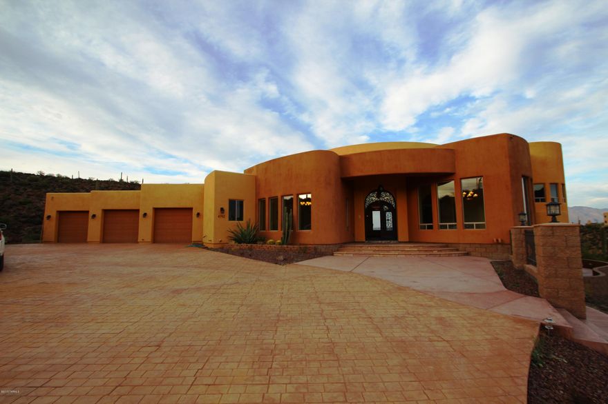 Nestled up high this privately gated custom home has it all from gorgeous City & mountain views & open valley all around, to Spanish ramada & exotic indoor water fountain! Enjoy the 3.3 acre serene desert beauty tucked away from busy life with being conveniently close to downtown U of A, I-10 & Tucson Central. Bright open floor plan offers marble flooring, cathedral ceilings in living room & large BR's. Chef's kitchen offers cherry tall cabinets, granite counter tops, SS appliances & a fire place. Pamper yourself in your own oasis with sparkling pool spa, water fall, BBQ grill/ramada. Master BR w/exotic marble floor & tub and dual vanity offers much tranquility & comfort with it's own private patio overlooking City & Mtn. Truly a gem that could be yours!