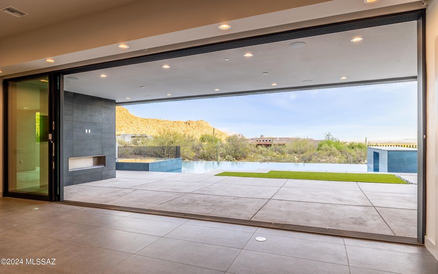 Spectacularly stunning modern contemporary new built home in guard gated Canyon Pass at Dove Mtn. 2024 completed construction-never lived in. Home boasts 5 fireplace locations-3 interior, 2 exterior, floor to ceiling high end Fleetwood Windows which bring in panoramic viewing from every room. Grand gourmet kitchen w/the highest end appliances & modern sleek cabinetry, along with a full wall showpiece wet bar! A one-of-a kind dramatic entry door, 8'x10' pivot style. Backyard oasis paradise w/endless views, sleek long pool w/negative edge spa, grotto waterfall, city lights, numerous mountain views. Cul-de-sac street. Pool lighting is spectacular! Kitchen is spectacular Entire house is breathtaking!  Want modern contemporary w/no steps? -this is your home! Seller Open to Consider ALL Offers.