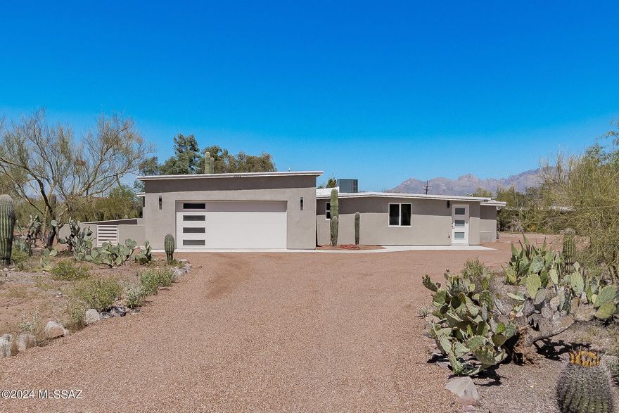 MOUNTAIN VIEWS! This gorgeous gem on nearly an acre lot with natural desert landscaping boasts breathtaking attention to detail throughout! You'll love the tastefully renewed interior showcasing a formal dining room with a beautiful wet bar and a large living room with sliding glass doors leading to the back patio. Wood-look LVT flooring, custom crafted cabinetry throughout kitchens and bathrooms, and recessed lighting that illuminates every corner are features that can't be left unsaid. Upscale kitchens include stainless steel appliances (KitchenAid in main home and Frigidaire Gallery in Casita), pristine quartz counters, plenty of white cabinets & cupboards, beautiful herringbone tile backsplashes, and a breakfast bar in the main house. Venture to the bright main retreat, which provides a walk-in closet and an ensuite with dual sinks and an enclosed glass shower. A unique attribute of this beauty is the fabulous Casita, fully equipped with a great room, kitchen, 2 bedrooms, and a bathroom. Both homes have been completely remodeled (new energy efficient windows, new finishes throughout, new HVAC systems, new water heaters, new septic, just to name a few items) and a substantial portion of the home is new construction, as is the garage. The low-care backyard has a covered patio with stunning mountain views where you can enjoy morning coffees or evening chats. This rare find won't disappoint. Make this dream home yours today!