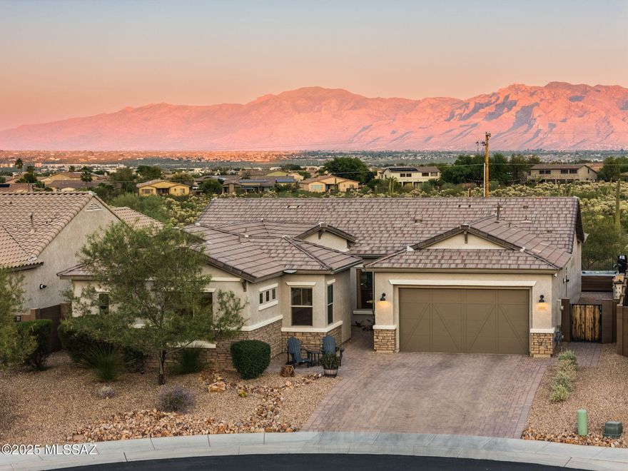 Wake up to the majesty of Saguaro National Park outside your front door then unwind each evening with panoramic views of Tucson's mountain ranges from your backyard. Surrounded by the tranquility of the Sonoran Desert, you'll still enjoy the convenience of being minutes from grocery stores, restaurants and I-10 for effortless access around town. Set within the gated Lazy K Bar Ranch, this four-bedroom former model home with split floor plan sits peacefully on a quiet cul-de-sac and features thoughtful upgrades throughout including hardwood flooring, unique kitchen backsplash windows, a built-in audio system with whole-home speakers, and an extended floor plan that expands both the family room and café for extra comfort and space. The flexible formal dining room could easily become a home office or den, while the spacious walk-in pantry effortlessly stores bulk groceries, small appliances, and extra kitchenware. Perfect for multi-generational living or hosting long-term guests, the private guest suite includes its own entrance, living room, walk-in closet, and en-suite bathroom. Step outside to a beautiful east-facing backyard with a view fence, gated dog run, hot tub, lighted barbecue area, and gas stub ready for a built-in fire pit or grill. Meticulously maintained, this home combines the best of desert living and modern convenience. Owner/agent
