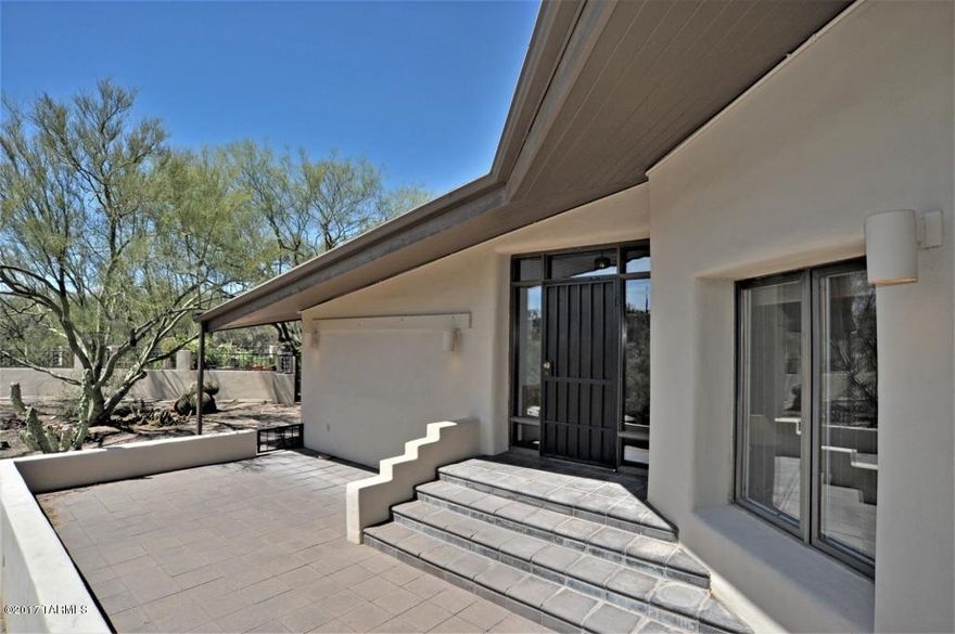 Contemporary 1978 custom mud adobe home in the heart of the old Foothills. This 2 bedroom 3 bath gem is carefully hidden on 2.5 Acres with views of the Catalina Mountains that don’t stop from every room of the house! Interior concrete tiles add character and charm. Enjoy a cozy fire in your open living area with separate reading room/den. Master suite with his and hers baths and closets with optional sitting room or office space. Four patios to choose from to sit outside and enjoy your private desert oasis. Newly remodeled kitchen with a built-in breakfast table placed strategically in front of a wall of windows to bring the outdoors in. Plenty of storage in your large garage with a spacious workshop area off the laundry room.