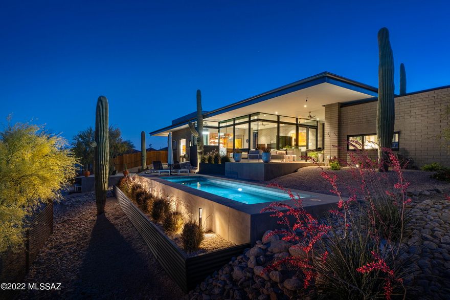 A pure expression of modernist lines, with walls of glass that frame the surrounding desert landscape creates a sense of infinite openness, while accentuating the dimensional massing of space. Designed and built by renowned firm Repp + McLain, this highly in demand home vernacular stuns with its distinctive amenities and bespoke design elements, offering a level of architecture that is beyond compare. Enter into a light-filled and resplendent floor plan that runs North and South along the topography, maximizing the discrete, yet dramatic view corridors. Replete with polished concrete floors, exposed insulated Integra block, juxtaposed against smooth finished plastered walls, provides both a visual and tactile experience. The generous owner's suite is privately sequestered on the South wing of the residence, featuring an oversized walk-in dressing closet and luxuriously finished primary bath, which includes a large soaking tub, walk-in shower, floating walnut vanity adorned with Hansgrohe fixtures, as well as a private outdoor shower. The public North wing comprises the living room, dining and kitchen efficiently showcased in a greatroom format, creating a warm touchstone of unassuming balance, with custom walnut millwork, dressed in a quartz countertop, carefully choreographing the users movement throughout the space. Fitted with top end Wolf, Sub Zero, Miele and Asko appliances, the kitchen features a butler's pantry strategically situated out of frame, providing a supporting role to all preparation activities. 

From sunrise to sunset, the interplay of light and shadow shifts, acting in concert with the home, illuminating the complementary materials on display. Floating roof lines produce a strong graphic both horizontal and vertically, responding to nature's elements, while enhancing the quality and scale of the interior spaces. A large covered patio provides seamless flow from the interior to the exterior of the great room, creating an extension of the outdoor living floor space. An elevated patio with a masonry fireplace, overlooks the pool and view deck, while providing an open air access to the guest pavilion. A security coded entry gives way to a private guest en-suite and dedicated office, located at the far North end of the residence, offering a sense of privacy that is perfect for family or guests alike.



Accessed through a breezeway, the oversized garage provides ample storage, with an adjoining home gym (not included in the home's square footage), with sliding glass doors that open up onto a covered patio. The owned solar system generates supplementary power for the home, harnessing the natural resources, while optimizing cost efficient energy. This timeless modern design is thoughtfully executed and combines not only significant spaces for both indoor and outdoor entertaining, but also perfectly scaled private spaces for comfortable everyday living.