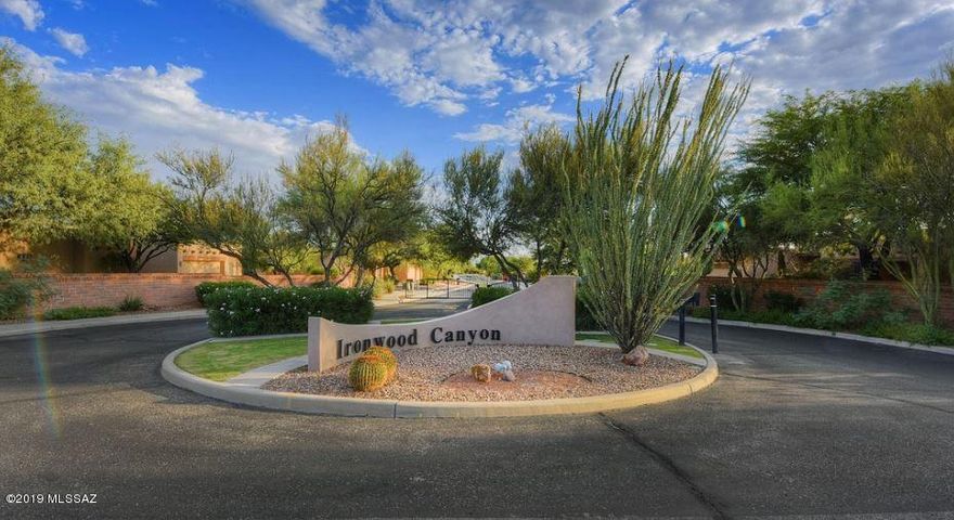 Semi-Custom Santa Fe 4/3 2 car garage on near 1/2 acre in exclusive, gated Ironwood Ranch in Oro Valley. True E/W exposure w/ glorious Pusch Ridge Views! Stylish designer upgrades throughout leaves nothing to be desired. Your dream kitchen awaits w/ two-tone cabinetry, granite counters, eye-catching back-splash, SS appliances, wet bar & a massive island. Kitchen opens to family room w/ a cozy gas beehive fp & custom built-in entertainment center. Extensive master suite includes french doors, pool access, grand master bath w/ glass enclosed shower, separate soaking tub, his & her vanities, & a generous walk-in closet. Beds 2&3 share an updated jack & jill bath. Bonus room provides endless possibilities. The professionally landscaped yard offers heated pool/spa, waterfall, flagstone & views!