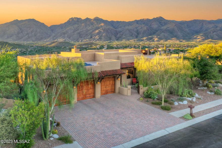 Dramatic hilltop custom retreat - breathtaking Foothills Mtn & City views in Double-Gated Sabino Mountain-great lock & leave. Modern SW contemporary single story split plan-built masterfully with premium, warm finishes. Foyer leads to a wall of windows. Features: Owned '21 solar, quartz stone floors, high ceilings, open great room, gourmet kitchen, generous primary suite-dual walk-in closets. Expansive covered porch & patios with upper mezzanine terrace, gas fire-pit & BBQ & stunning desert specimens. 3-car oversized garage, gorgeous woodwork. Flex/3rd bdrm is double sized & easily converts to 4th bdrm. Around the corner from Ventana Canyon CC & Canyon Ranch Spa. Healthy living-Private community pool/spa, Bike to Sabino Canyon & Tucson's 130 mile Loop Trail. Shopping & great restaurants