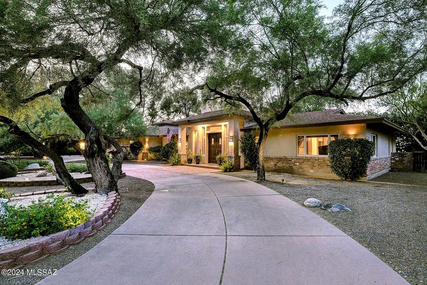 Stunning and gracious remodeled home situated on a lushly landscaped 1/2 acre homesite in prestigious gated Tucson Country Club. Double door foyer entry, exquisite Great Room w/16 ft. high ceilings, dramatic stone fireplace, built-in lighted art display bookcases, formal dining rm w/wet bar, 2-way fireplace, sensational gourmet island kitchen w/gorgeous granite countertops, breakfast bar,  stainless steel appliances, gas stove top, double ovens, extra prep sink, refrigerator, wine cooler, pantry, solid wood plank floors, incredible library/study w/18 ft. high ceilings, walls of bookcases, 5 bedrooms (split plan), 5 baths, tile floors, wood cased windows, a charming Secret Garden , pantry/laundry room. Enjoy the fabulous backyard w/covered patio, pool, gazebo, fruit trees & serene setting