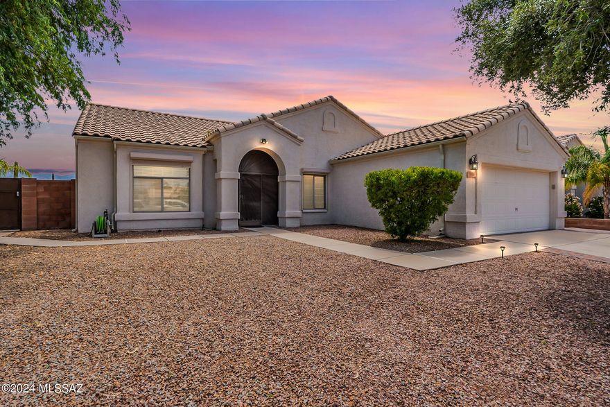 LOCATION, VIEWS, AND PRIVACY! This one-story, steel framed, block constructed, contemporary home is steps from Ironwood Elementary in the Marana School District, with unobstructed mountain views, & backing to 40+ acres of open desert. Pebble Tec pool & spa in low maintenance yard (artificial turf, brick paver patio, built-in BBQ, covered patio & rain gutters). Open floorplan has 4bd/2ba, vaulted ceilings, scored concrete & luxury vinyl floors, corner gas fireplace, stainless appliances including fridge. Primary suite includes large, remodeled shower, dual sinks and walk-in closet. HVAC new in 2022. Enjoy low monthly electric bills with solar lease & great security with custom steel gate + keypad entry, rolling shutters & iron security door.