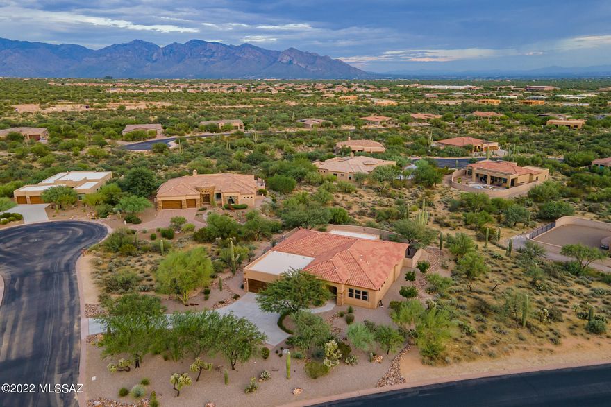 Enjoy views of the Catalina Mountains from the large spacious yard! Welcome to a like-new and luxurious A.F. Sterling home in Tortolita Vistas, a private gated community near Dove Mountain, where all lots are over ¾ Acre. While the homes are very private, it's a friendly community where homeowners know and trust each other and have occasional neighborhood gatherings.  The handsomely landscaped front yard leads to a charming front porch area and an elegant double entry door of iron with set-in screen features, providing an opportunity for cross-breezes on our cooler days and setting the stage for this beautiful home. A coffered ceiling accentuates the entryway and views across the great room of the lush Sonoran Desert beyond the home. A spacious den/office/TV room is adjacent to the entry. With a popular open floor plan showcasing large spaces, the dining room can hold a table adequate for "friends and family", while the great room is also comfortable for relaxing or entertaining. The ample breakfast room is adjacent to the breakfast bar, providing a plethora of seating options and access to the rear patio and yard. A well planned kitchen features granite counters and handsome wood cabinetry with pull-out features for easy access. The pantry also has pull-out shelving. A five-burner gas cooktop and wall oven provide excellent cooking options, along with the outdoor kitchen built-in barbecue nearby. The gas cooktop is accented with a tiled custom scenic backdrop, and subway-style tiles provide a stylish backsplash throughout the kitchen. An island provides additional storage. The nearby laundry room is large, with built-in cabinetry for storage of laundry/cleaning supplies (note the newer Samsung washer/dryer, included). The home is a split floor plan, providing three smaller bedrooms and two full baths on one side, including one bedroom with an en-suite bath. The expansive master bedroom enjoys views of the Catalina Mountains and has another handsome iron door to the outdoor covered patio, with plenty of room for a large reading chair. A spacious walk-in closet plus another smaller closet outfitted with cubbies (by California Closets) provides significant space for clothing and sundries. The primary bath has double sinks separated by a seated make-up counter, a separate WC, and a large walk-in shower with double shower heads. The rear yard encompasses a well-sized (extended) covered patio, an outdoor kitchen with a built-in barbecue, and room to add a pool while enjoying views of the Catalina Mountains and desert greenery in a private setting. The large 3-car garage includes upgraded garage doors and epoxy-finished floors. This like-new home is spotless, perfectly maintained and move-in ready for you. All services, groceries, and other needs, and restaurants are nearby, with quick access to both Oro Valley and I-10 for downtown Tucson and Phoenix. Furnishings may be available on a separate bill of sale. We look forward to showing you this lovely home at your earliest convenience.