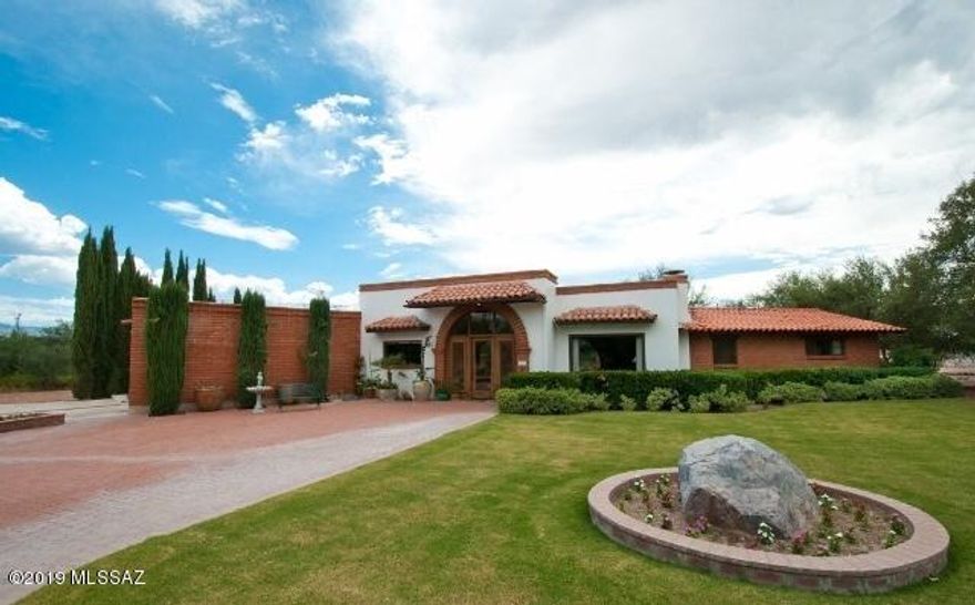Experience classic Tubac style in this sprawling burnt adobe brick home, nestled on the second hole of the Tubac Golf Resort and Spa. Situated on a quiet cul-de-sac, you'll find stunning architectural details in this open-concept beauty, including exposed beams, a wood-burning fireplace, Saltillo tile, and sophisticated arched doorways and windows. Warm and expansive kitchen with roomy seated peninsula: perfect breakfast bar or buffet. Luxurious and spacious owner's suite with adjoining den and two closets plus roomy bath. Outdoor space includes a large fenced backyard with a covered patio; here you'll find the ideal spot for outdoor seating, dining, and entertaining. Home includes a private well. Come enjoy Tubac living.