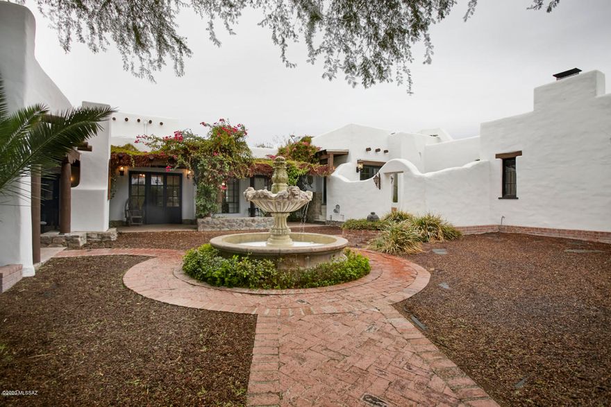 Ooh La La! This one is juicy! I live for these!
Listed on the National Historic Register, a 1920's mud adobe with all the ambience of a movie set. This adobe walls encompassing courtyards and patios, too many to count.  Warm wood floors and beamed ceilings. Designed by William Penhallow Henderson, a painter, architect and furniture builder from Santa Fe.  The mud bricks were all made and baked on the property by a crew of 8 native Puebloans, thus the name Indian House Road.  This home is the original in the enclave.  On over an acre, well located centrally you have fine privacy yet close to schools and shopping. property includes 6 bedrooms, 6 baths, owned solar, a well, a Guest house w/ theater incl projector and screen. Huge yard lined with citrus trees, big enough for a soccer field.