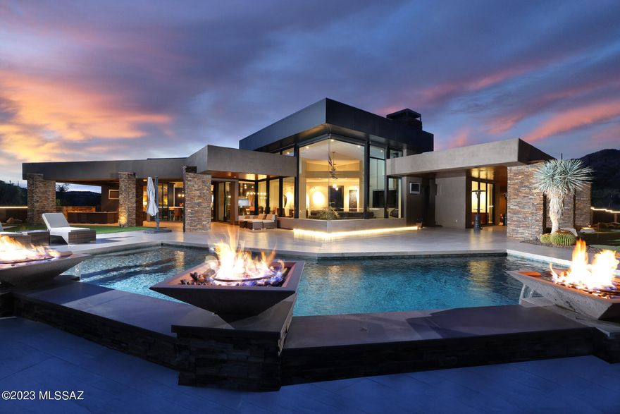 Welcome to this exceptional modern-contemporary in Oro Valley's prestigious Stone Canyon Club; the premier guard-gated golf community in So. Arizona. Featuring elevated panoramic views of the Catalina Mountains and Tuson city lights. The long private driveway leads to the dramatic 25-foot waterfall and beautiful entry. Once inside enjoy walls of glass displaying unobstructed mountain views and extensive outdoor living space. The master suite, secondary bedrooms, and office are all beyond spacious. Distinctive limestone flooring is predominantly featured throughout the home, along with wood flooring in the office, and beautiful porcelain tile for the expansive exterior living space. The gourmet kitchen features Wolf and Sub-Zero appliances. The oversized 3-car garage features an air-conditioned workshop, large storage closet, and epoxy flooring. The outdoor living space features 1,500 square feet under roof, outdoor kitchen, beautiful linear fireplace, built-in hot tub, heated pool with fire and water features, putting green, pool bathroom, and of course the amazing mountain and city views. Additional features include Central Vac, custom lighting and audio throughout the interior and exterior, motorized windows in the great room, motorized interior shades and exterior solar screens, three dishwashers, warming drawer, wet bar, spa-like master shower, stunning powder room, beautifully designed landscaping, and backyard privacy wall lined with porcelain tile. Stone Canyon Club is the premier, private, 24-hour guard-gated golf community situated on 1,400 acres in southern Arizona in the foothills of the Tortolita Mountains in Oro Valley, Arizona. It offers the Jay Moorish Signature Design championship golf course, a luxurious health and fitness facility, a gourmet restaurant and bar, as well as leagues, clubs, and amenities for all ages.
