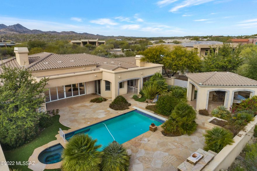 Enjoy your own private oasis and FABULOUS VIEWS of Pusch Ridge from this beautiful 5 bedroom/4 bath home in desirable guard-gated Honey Bee Ridge within the Rancho Vistoso Community of Oro Valley. Fantastic floor plan boasts several private patios, 2 large living areas, 2 fireplaces, plus 1 by the pool, and plenty of storage and space for everyone. Enjoy indoor/outdoor entertaining with expansive sliding glass doors in the living room leading to the pool, spa, and outdoor kitchen. A special dog run is a feature off the garage, plus an artificial turf side yard. Kitchen features a Sub-Zero refrigerator, and Jenn-Air double ovens.  Home sits far off the street on 1 acre, with over 4,300 square feet and a 3 car garage, plus a spacious concrete aggregate driveway. Don't miss!