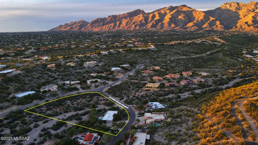 This elegant masonry home sits on an incredible 2.8 acre lot in a quiet neighborhood of no through streets. The lot is primarily a huge desert wash with lush desert vegetation and wildlife corridor.  The home is definitely surrounded by an environment of peace and tranquility that can be enjoyed from the huge covered back patio and pool area. The home features water harvesting and a garden with raised planting beds; new dual pane windows and sliding doors throughout; new exterior paint, gorgeous wood front door, and classic Tucson style.  The spacious master suite features a fireplace and access to the pool and yard.  The living room and family room share a two sided fireplace. The kitchen and large front covered patio face north east looking to the Catalina Mountains.