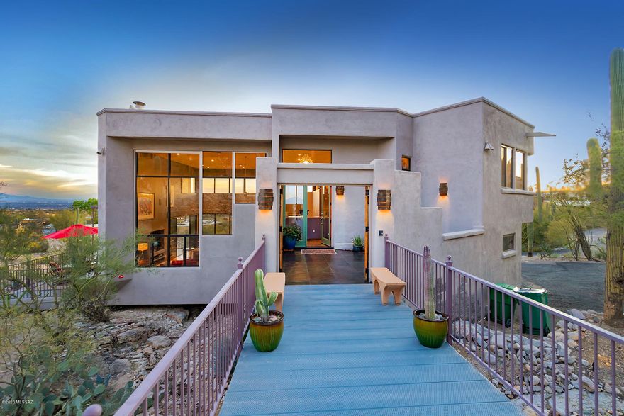 Forever views of the city & Coronado National Forest! Discover walls of windows in every direction, leading to spectacular rare & unique setting inside & out! All windows feature rolling shutters perfect for locking up & traveling! You will also fall in love this luxury contemporary home featuring a grand metal bridge entrance w/plenty of parking for guests, stunning great rm w/20 ft high ceilings! Cooks will enjoy the granite kitchen w/cherry cabinets, granite, hi-end appliances wet bar & laptop desk! Double sided gas FP, pool table/game area & spacious dining area-all opening to 2400 square ft of 3 luxury patios w/captivating city lights & mtn views! Enticing master ste w/spacious lounge area, spa tub w/FP & private viewing patio! 2 guest/children BR's/offices!