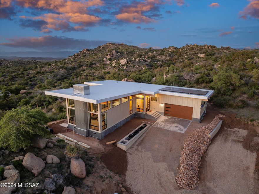 FINAL PRICE REDUCTION TO $859,000 / SELLER MUST SELL. Spectacular hillside home on 3.39 acres of natural beauty in desirable Cherry Valley, adjacent to National Forest and perched among huge granite boulder formations and lush vegetation.  

The panoramic ''best in Oracle'' views can be enjoyed from any room through the Pella windows, or from the expansive outdoor deck. Quality construction is evident in every detail, with engineered hardwood white oak flooring, pine tongue and groove ceilings, quartz/stone countertops throughout, and James Hardie board and batten exterior siding. Custom kitchen with 6 burner ZLINE range and drawer microwave, Beko dishwasher, pot filler, under sink hot water heater, and room for 42'' fridge. Tastefully designed bathrooms, with soaking tub and separate curbless shower in the primary suite. Split bedroom floor plan and sound deadening interior insulation help provide a calm working environment for the artist or musician.

The oversized attached 2-car garage with craftsman garage door & side mount Liftmaster opener provides ample parking or shop space.

Sustainable features include Tesla Solar system with battery storage, a heavily insulated 22 gauge metal roof that captures rainwater into a 1000 gallon tank with jet pump irrigation, and a separate gray water system that autofeeds a planting bed. 14" spray foam ceiling insulation (r value approaching 100), and 10" spray foam wall insulation help minimize utility usage.

Schedule a showing and experience the views for yourself!