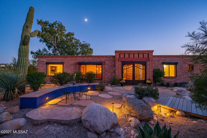 Classic Tucson Foothills Adobe Territorial which surrounds an enchanting courtyard with views to downtown Tucson. Kitchen- Viking, Bosch, SubZero and Electrolux appliances, Granite and more with custom  cabinetry. Rustic slate flooring throughout. Family room has beamed ceilings and a gas fireplace. The owner's suite w/fireplace sitting area & great closets. The Master bath features dual sinks, granite counters, slate shower with pebble flooring. All windows include rolling shutters for security and energy efficiency. Award winning grounds with privacy walls, fountains, & rock walls.  Outdoor entertaining area w/ benches, fountain, BBQ/kitchen. Easy care and beautiful retreat on a very private lot with city and mountains views. Energy efficient 7.2 KW Photovoltaic Solar